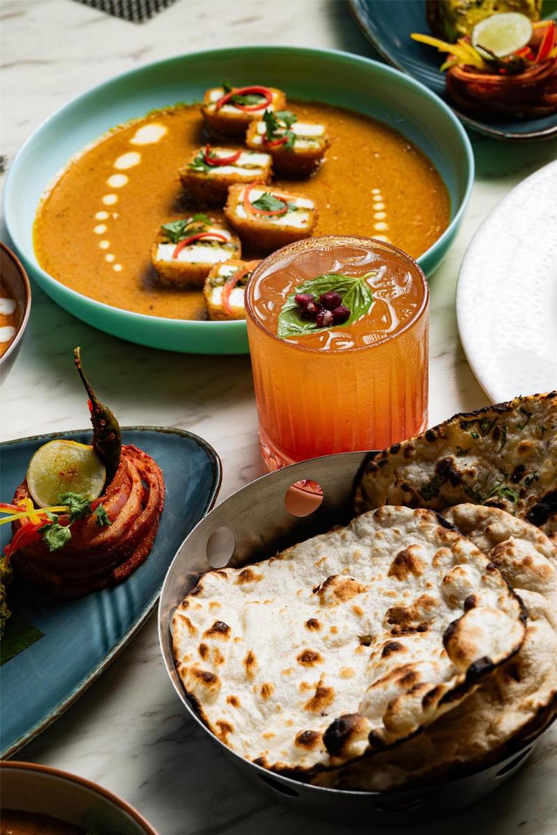 a table with plates of food and a bowl of soup at Radisson Blu Hotel Pune Kharadi in Pune