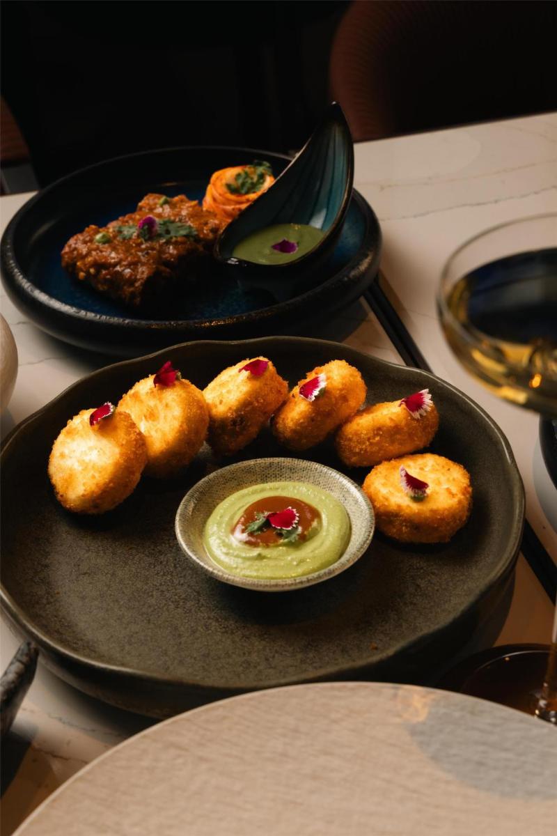 a plate of food on a table with a plate of food at Radisson Blu Hotel Pune Kharadi in Pune