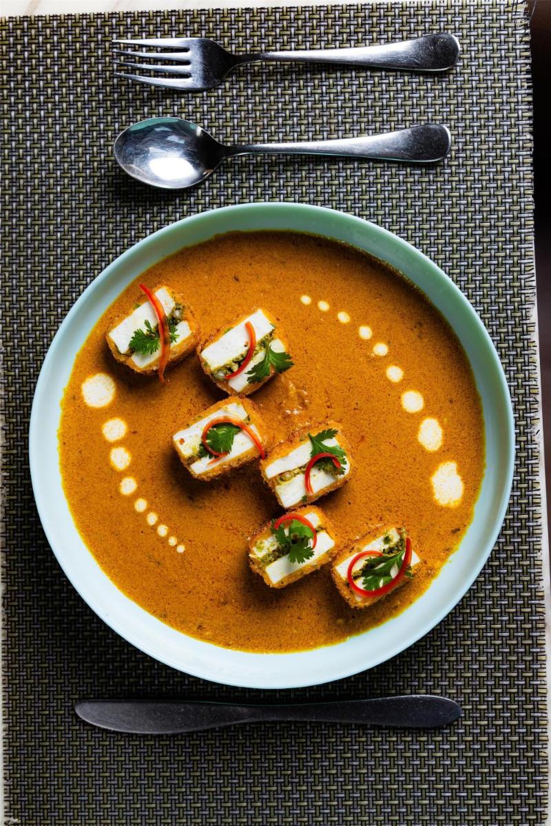 a bowl of soup with crackers in it on a table at Radisson Blu Hotel Pune Kharadi in Pune
