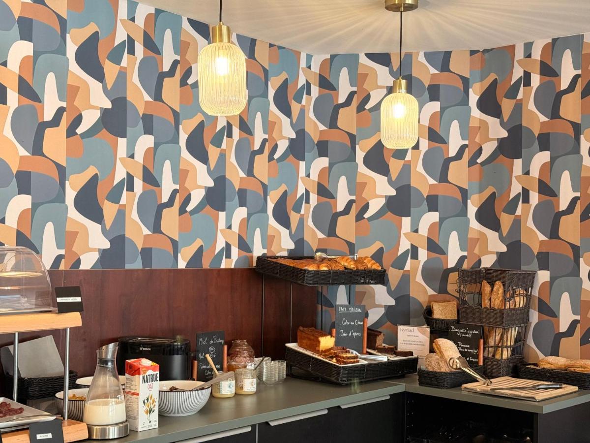 une boulangerie avec un mur à motifs avec des pâtisseries dessus dans l'établissement Kyriad Hotel Dijon Gare, à Dijon