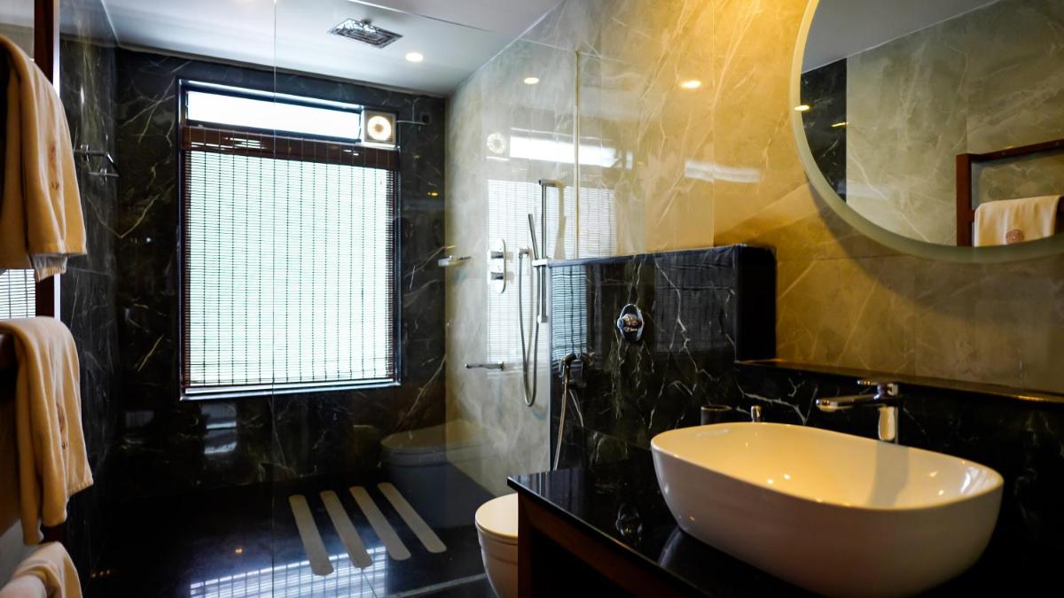 a bathroom with a sink and a mirror at WelcomHeritage Ayatana Ooty in Ooty