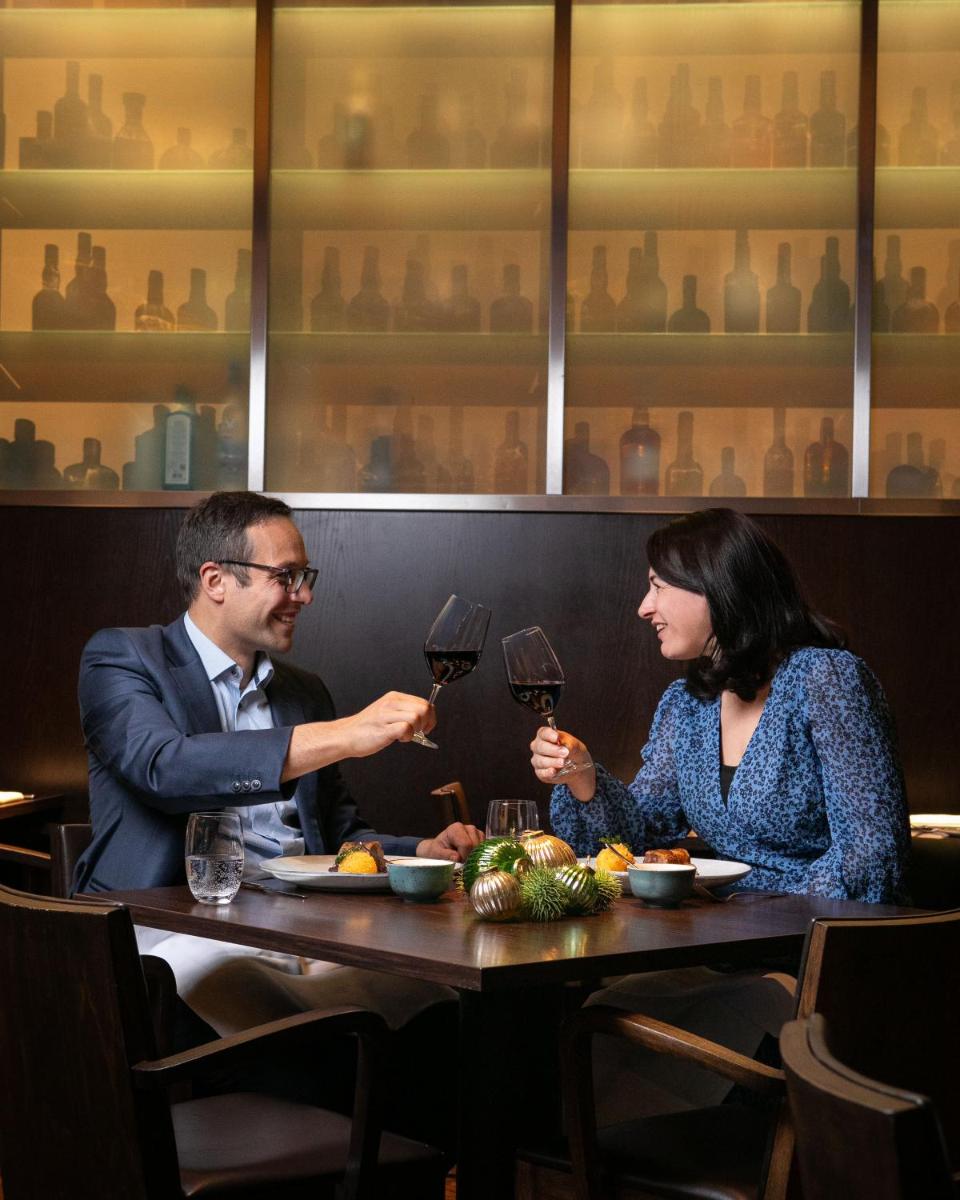 Ein Mann und eine Frau sitzen an einem Tisch mit Weingläsern in der Unterkunft Grand Hyatt Berlin in Berlin
