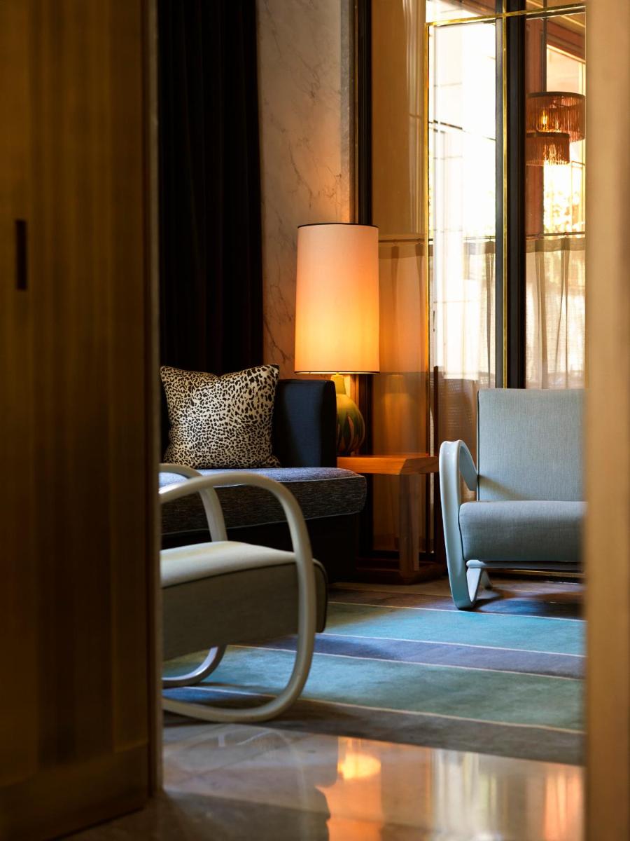 un salon avec un fauteuil et un canapé dans l'établissement Nolinski Paris - Evok Collection, à Paris