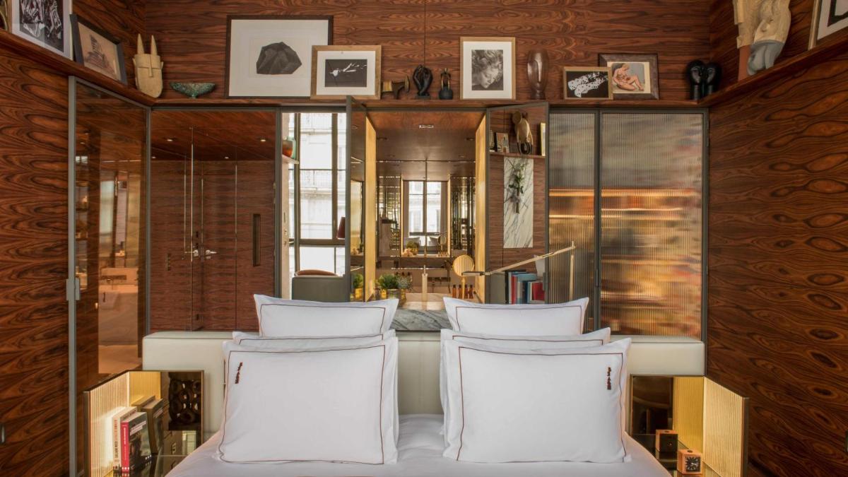 Cette chambre est dotée de chaises blanches et de murs en bois. dans l'établissement Brach Paris - Evok Collection, à Paris