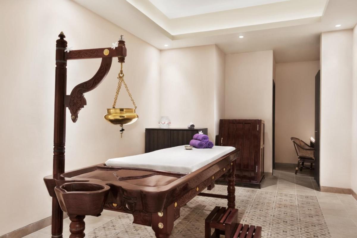 a room with a bed and a hanging scale at Ramada by Wyndham Lucknow Hotel and Convention Center in Lucknow