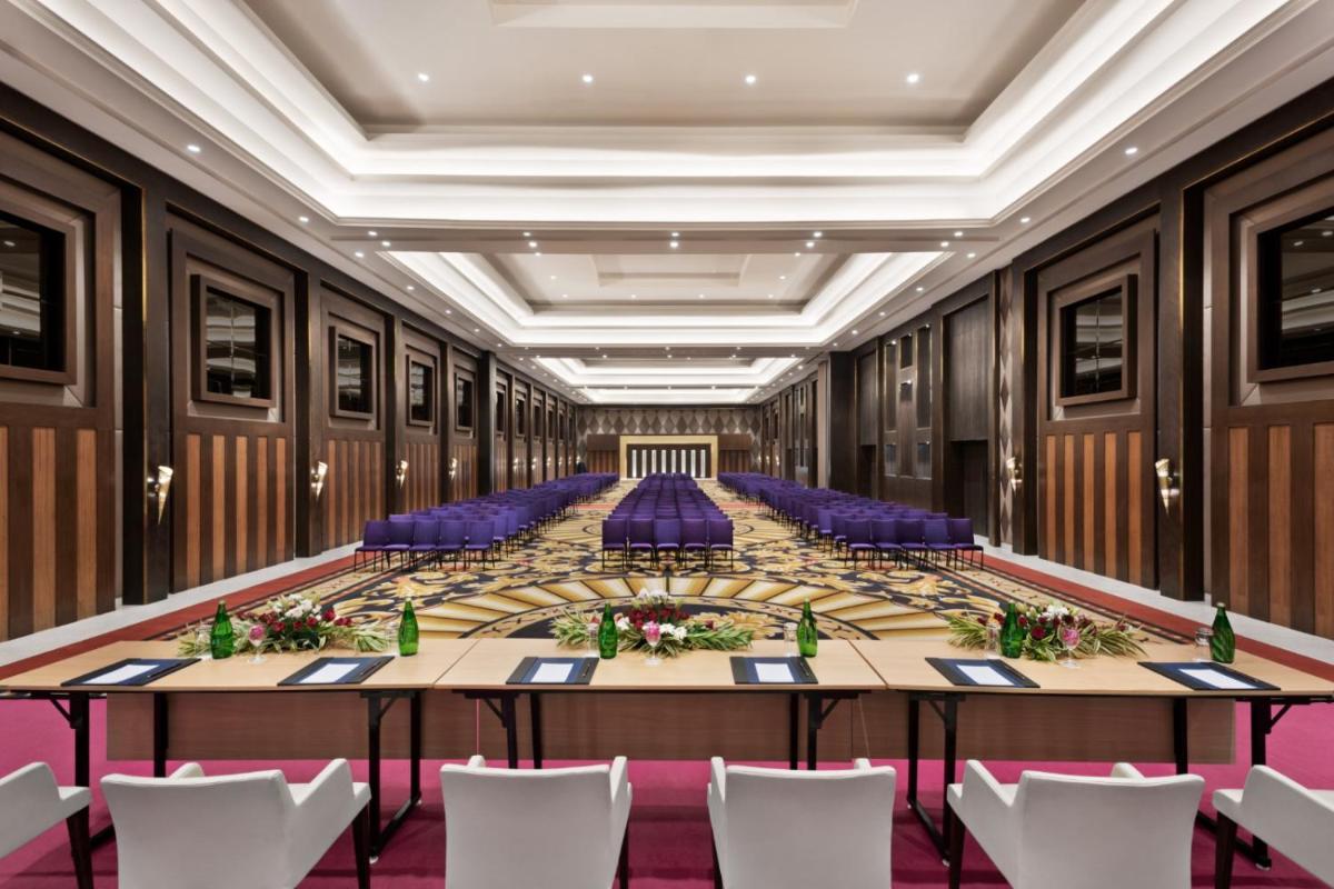 a large conference room with a long table and purple chairs at Ramada by Wyndham Lucknow Hotel and Convention Center in Lucknow