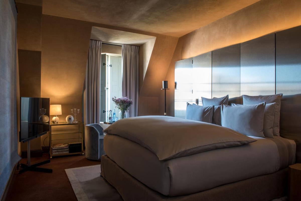 une chambre avec un grand lit et une télévision dans l'établissement Cour des Vosges - Evok Collection, à Paris