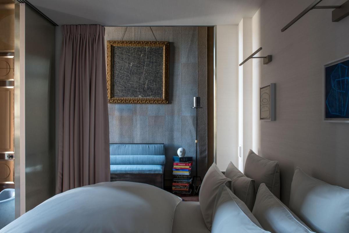 un salon avec un canapé et une chaise bleue dans l'établissement Cour des Vosges - Evok Collection, à Paris un salon avec un canapé et une chaise bleue dans l'établissement Cour des Vosges - Evok Collection, à Paris