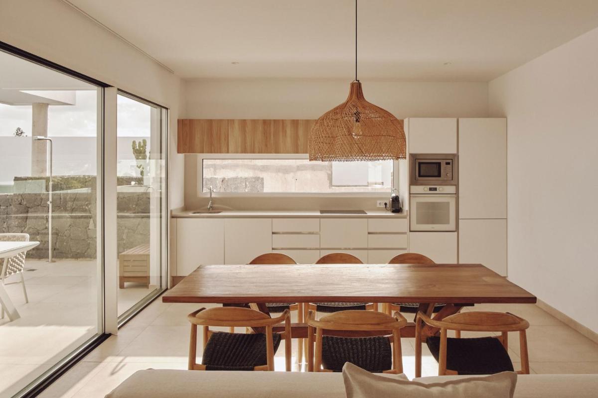 Una cocina y un comedor con mesa y sillas de madera. en Villas Alondra, en Puerto del Carmen Una cocina y un comedor con mesa y sillas de madera. en Villas Alondra, en Puerto del Carmen