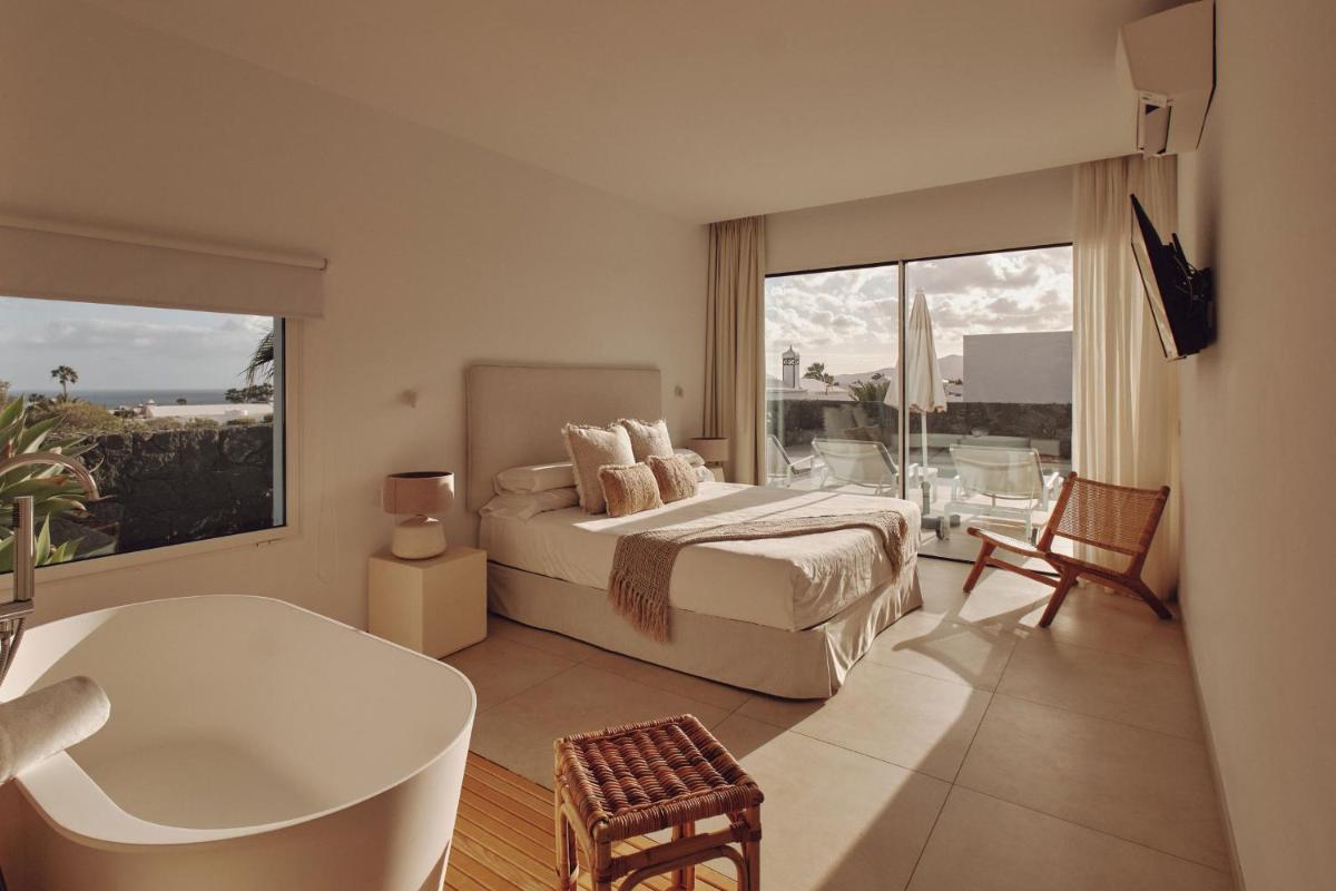 1 dormitorio con cama, bañera y bañera en Villas Alondra, en Puerto del Carmen 35 fotos más