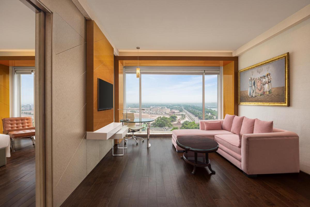 a living room with a pink couch and a large window at Renaissance Lucknow Hotel, Gomti Nagar in Lucknow a living room with a pink couch and a large window at Renaissance Lucknow Hotel, Gomti Nagar in Lucknow