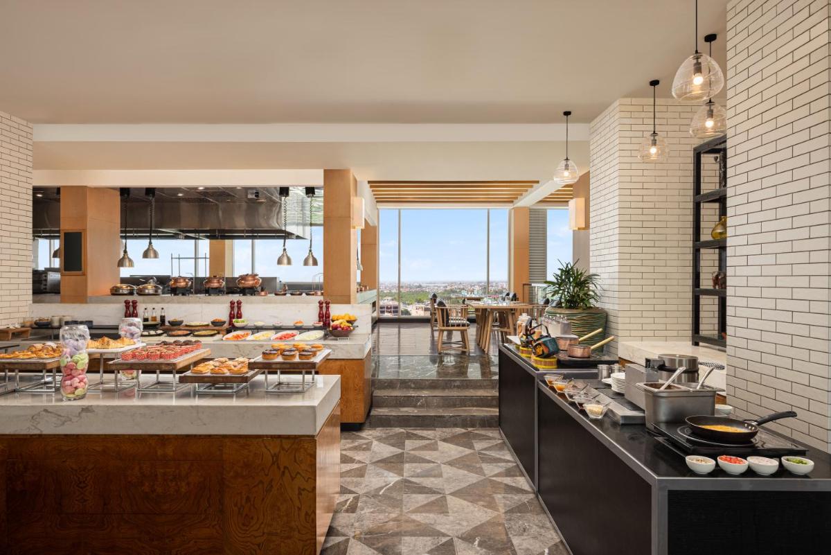 a large kitchen with a counter with food on it at Renaissance Lucknow Hotel, Gomti Nagar in Lucknow a large kitchen with a counter with food on it at Renaissance Lucknow Hotel, Gomti Nagar in Lucknow