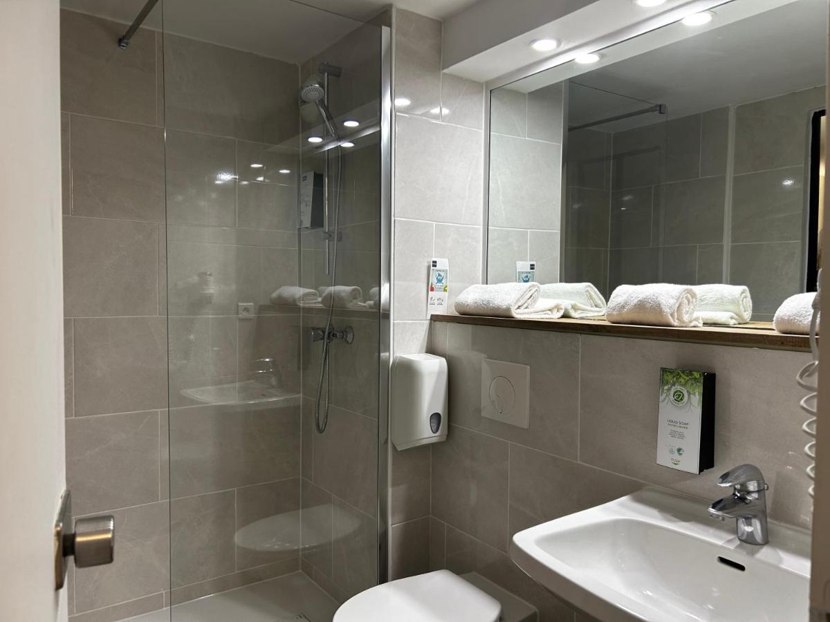 une salle de bains avec douche, toilettes et lavabo dans l'établissement Kyriad Carcassonne - Aéroport, à Carcassonne