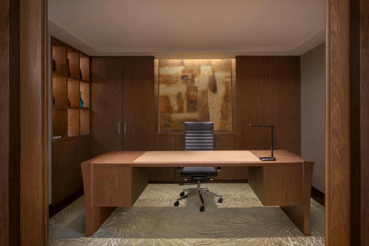 an office with a wooden desk and a chair at Bengaluru Marriott Hotel Whitefield in Bengaluru