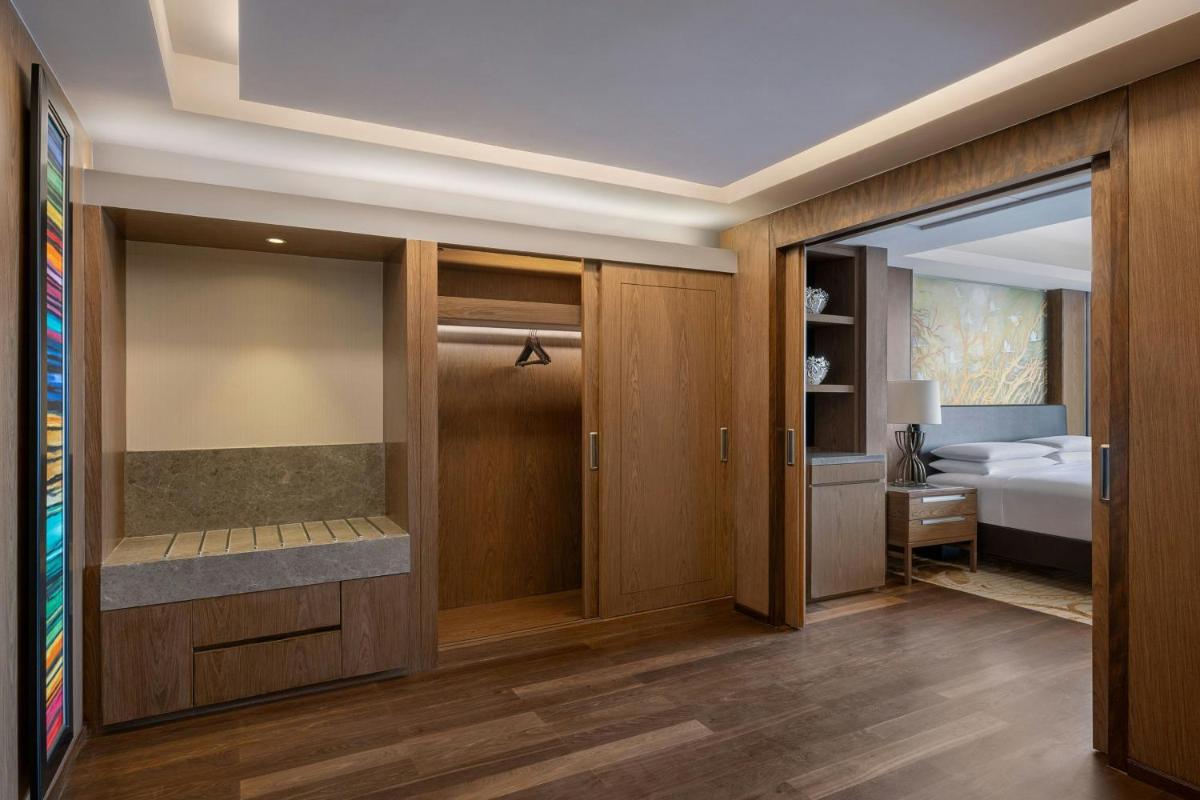 a hotel room with a bedroom and a bed at Bengaluru Marriott Hotel Whitefield in Bengaluru