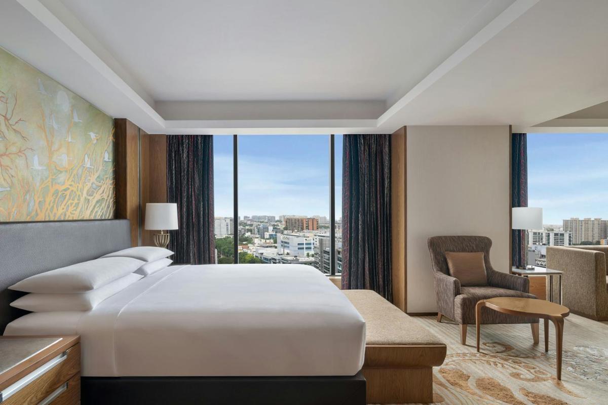 a bedroom with a large bed and a large window at Bengaluru Marriott Hotel Whitefield in Bengaluru