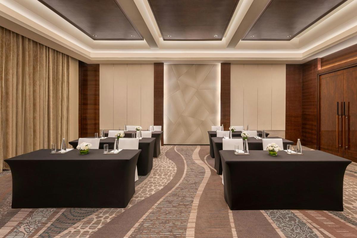 a conference room with rows of tables and chairs at Bengaluru Marriott Hotel Whitefield in Bengaluru