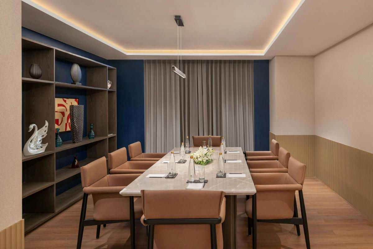 a dining room with a long table and chairs at Bengaluru Marriott Hotel Whitefield in Bengaluru