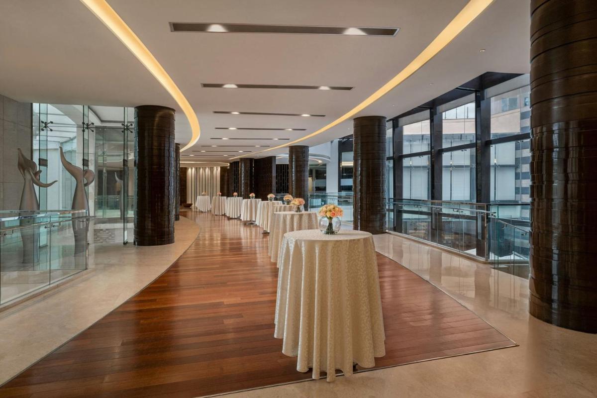 a row of tables in a building with windows at Bengaluru Marriott Hotel Whitefield in Bengaluru