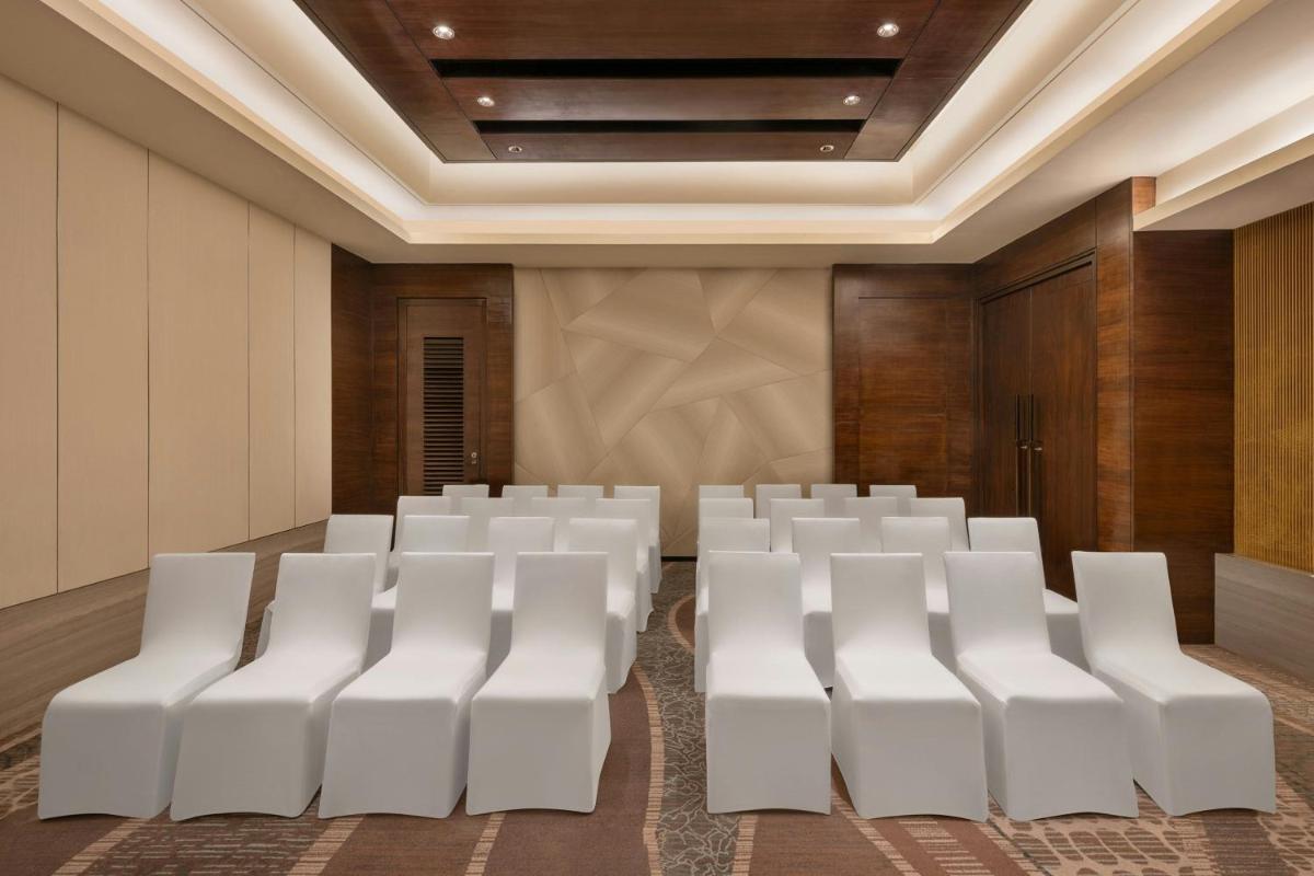 an empty conference room with white chairs in it at Bengaluru Marriott Hotel Whitefield in Bengaluru