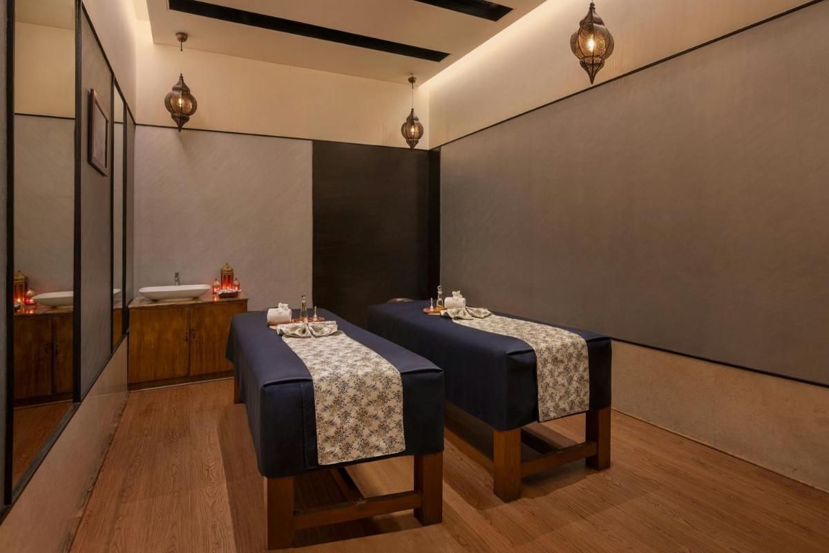 a room with two tables and a bath tub at Bengaluru Marriott Hotel Whitefield in Bengaluru