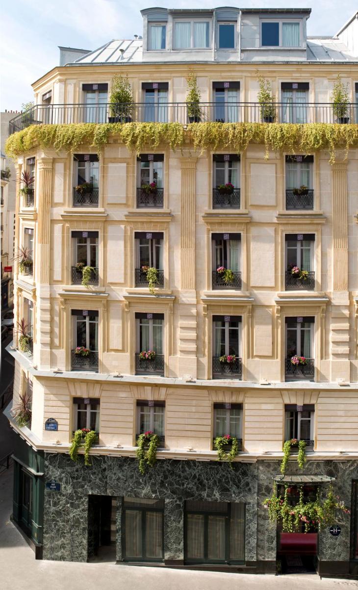 un bâtiment avec des plantes sur le côté dans l'établissement Grand Hotel Saint Michel, à Paris