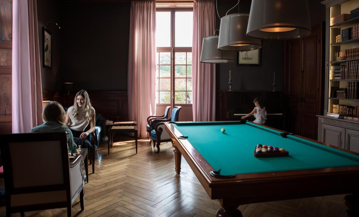 un groupe de personnes dans une pièce avec une table de billard dans l'établissement Château Sainte Sabine, à Sainte-Sabine