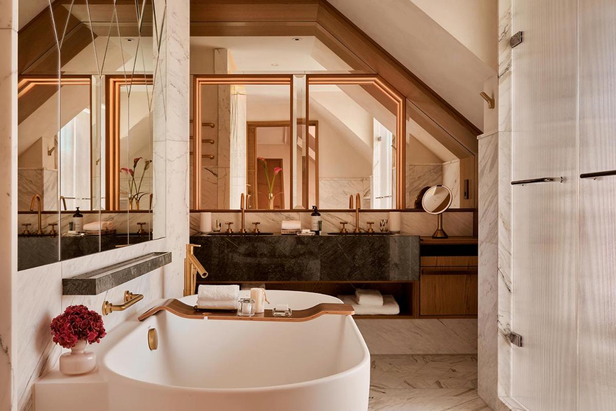 ein Badezimmer mit einer weißen Badewanne und einem Waschbecken in der Unterkunft Rosewood Munich in München