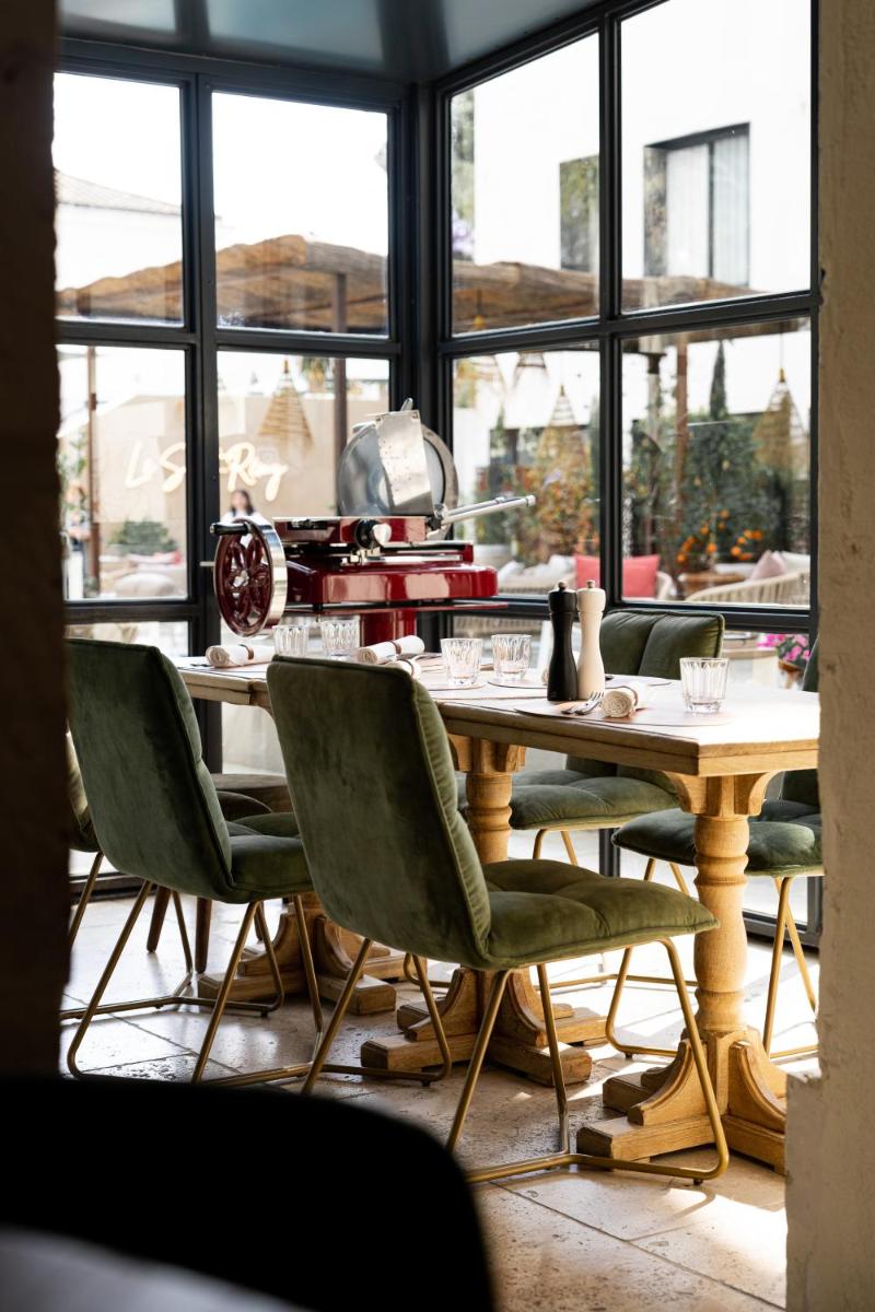une table et des chaises dans une pièce avec des fenêtres dans l'établissement Hôtel Le Saint Remy & Spa, à Saint-Rémy-de-Provence