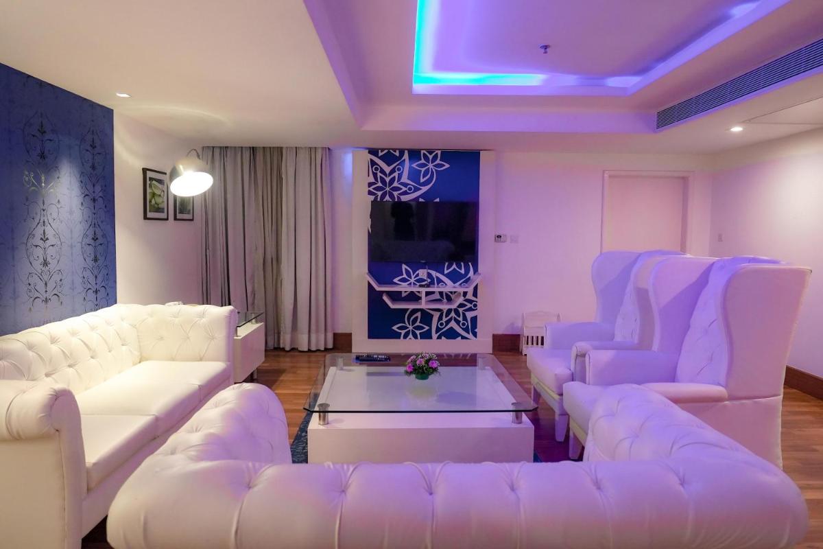 a living room with white couches and a table at Radisson Blu Kochi in Cochin