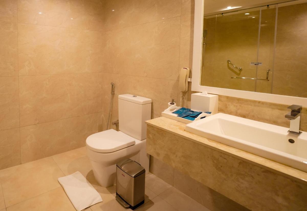 a bathroom with a toilet and a sink and a mirror at Radisson Blu Kochi in Cochin