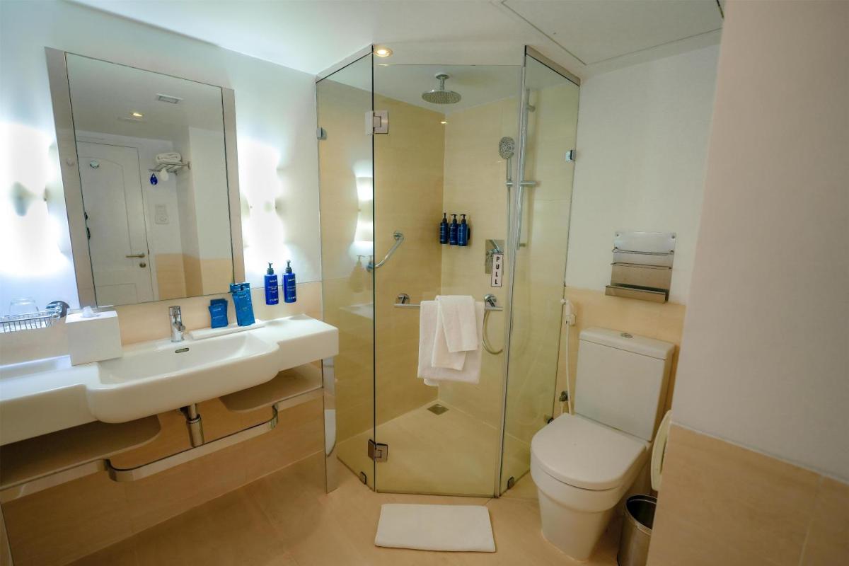 a bathroom with a shower and a toilet and a sink at Radisson Blu Kochi in Cochin