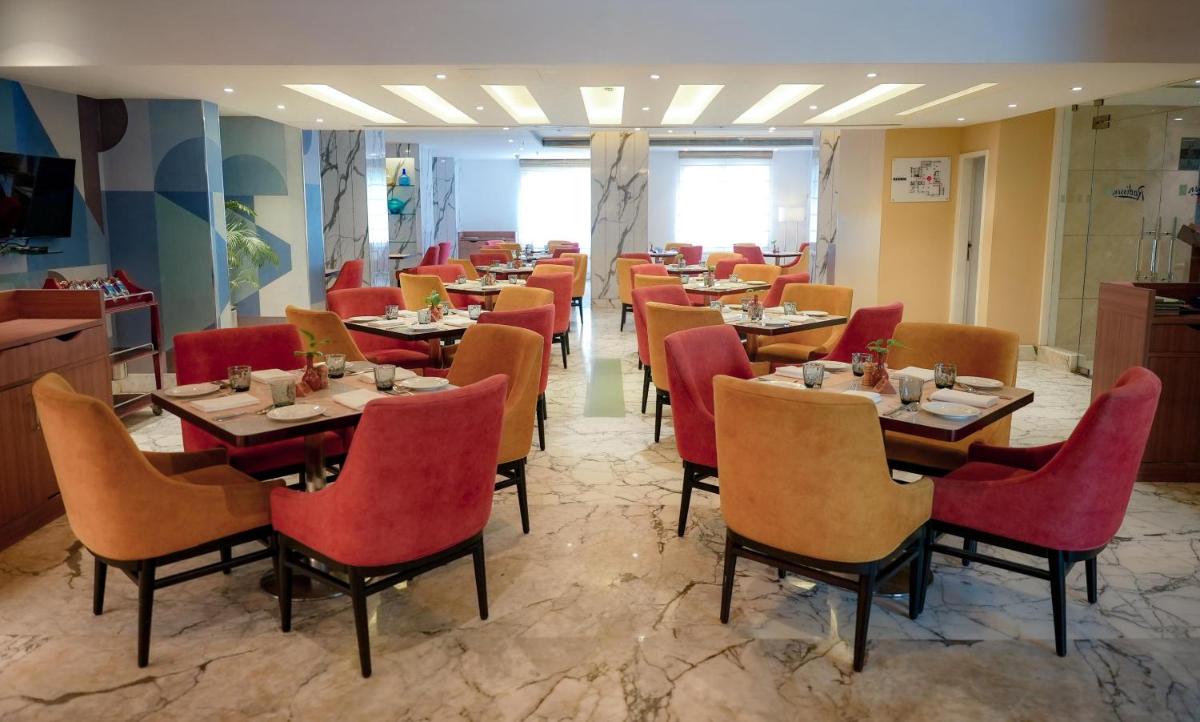 a restaurant with tables and chairs in a room at Radisson Blu Kochi in Cochin