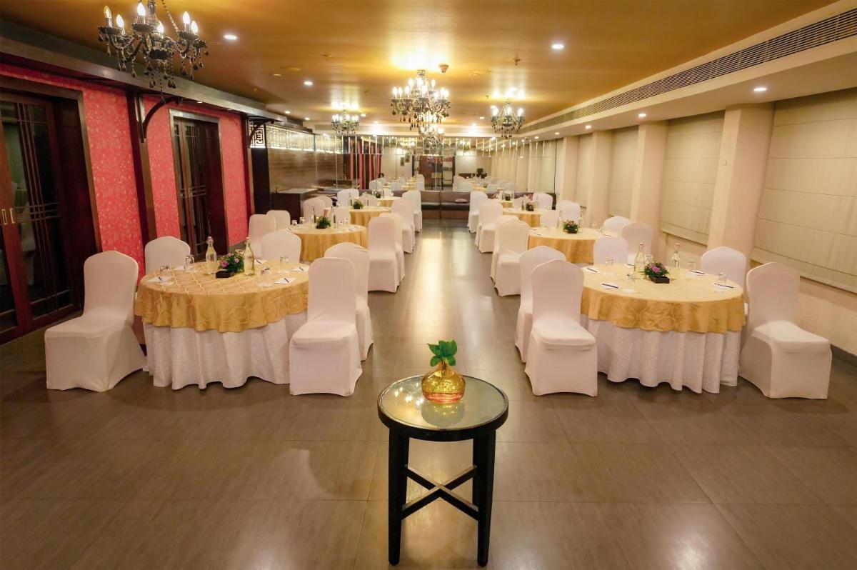 a banquet hall with white tables and white chairs at Radisson Blu Kochi in Cochin