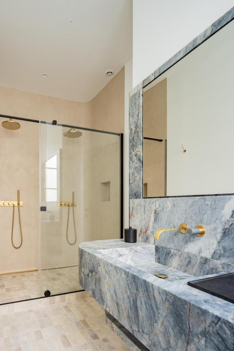 une salle de bains avec douche et un grand comptoir en marbre dans l'établissement 1.75 Paris La Source, à Paris