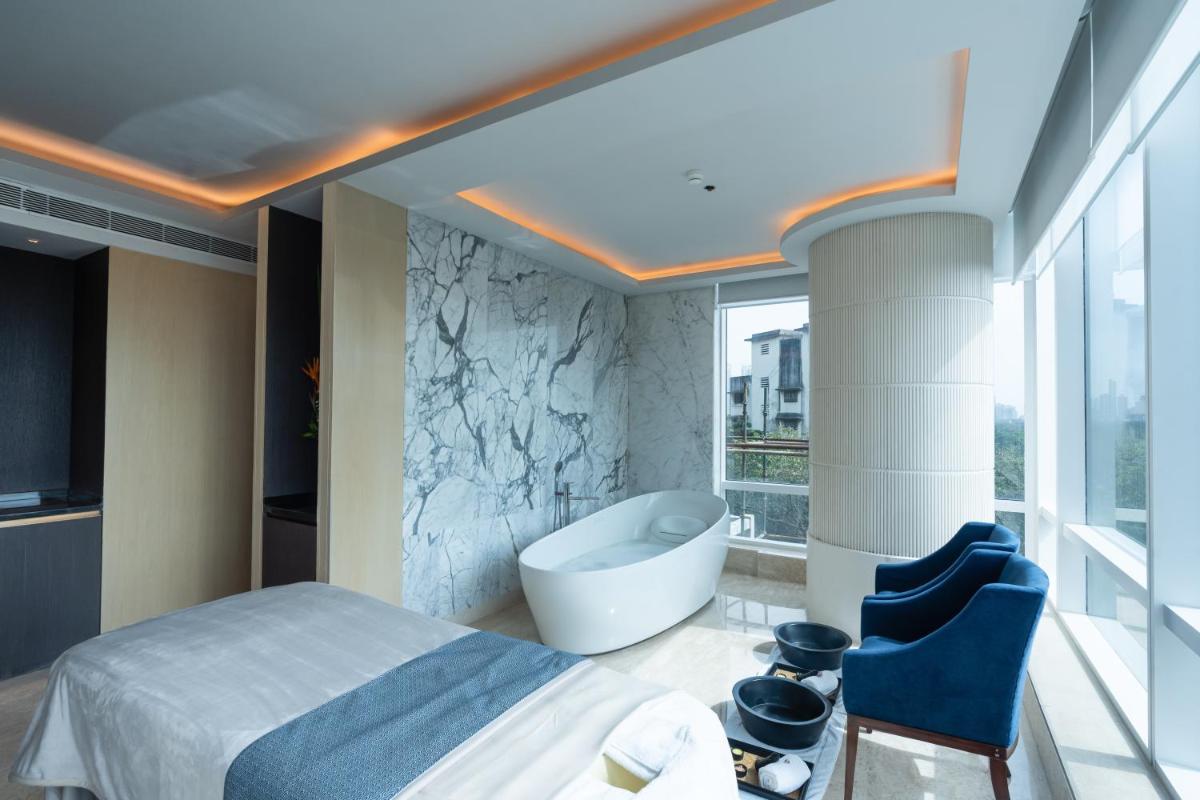 a bathroom with a tub and a bed and a bath tub at Four Seasons Hotel Mumbai in Mumbai