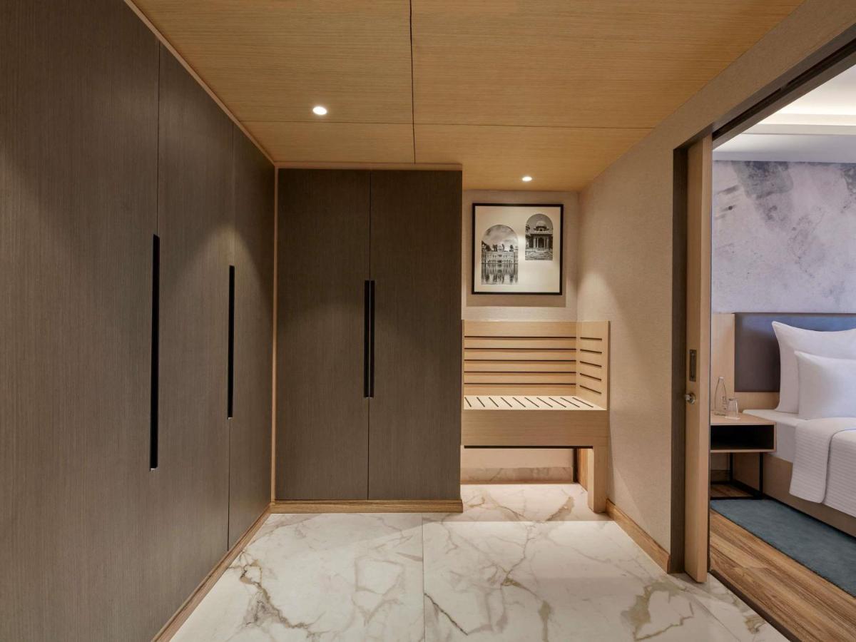 a small bedroom with a bed and a closet at Novotel Jaipur Convention Centre in Jaipur