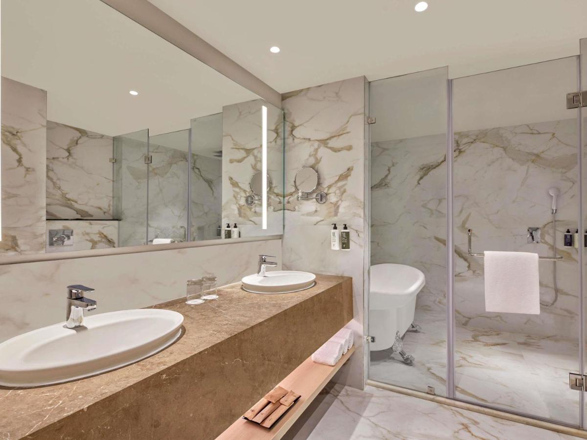 a bathroom with two sinks and a shower at Novotel Jaipur Convention Centre in Jaipur