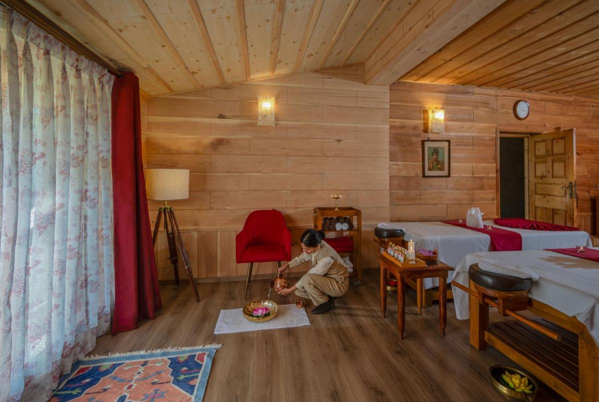 a woman sitting in a room with two beds at Storii By ITC Hotels Urvashis Retreat, Manali in Manāli