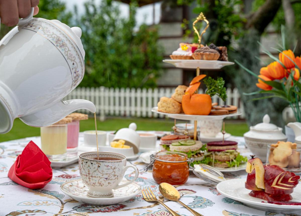a table with a tea set with food on it at Storii By ITC Hotels Urvashis Retreat, Manali in Manāli
