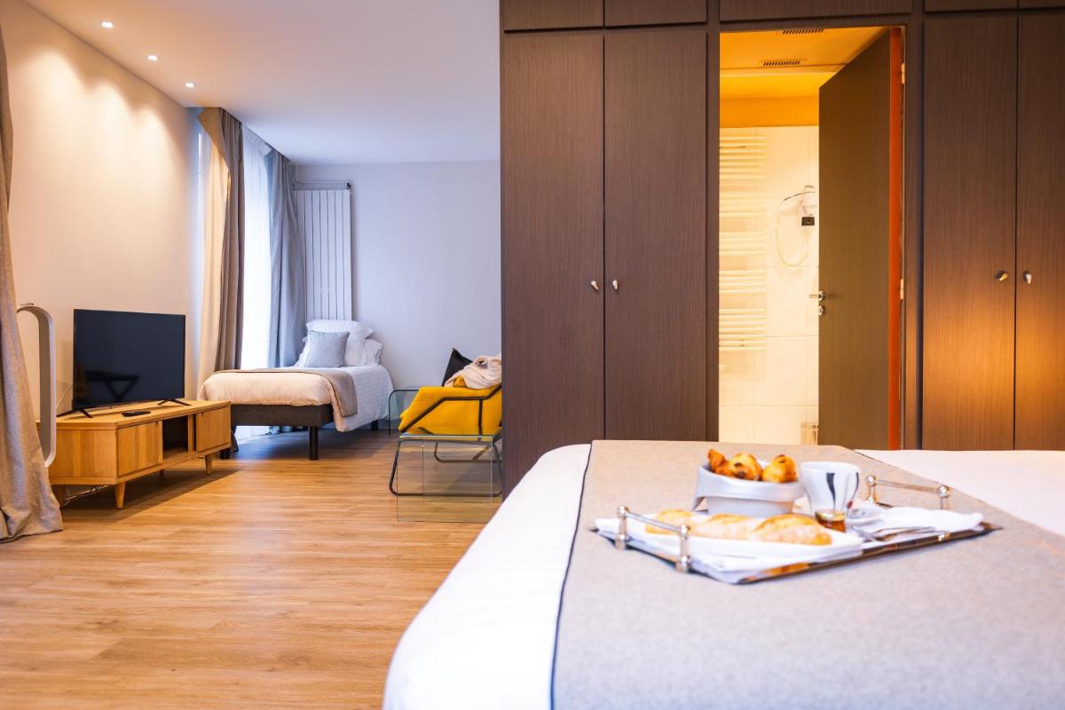 une chambre avec un lit sur lequel se trouve un plateau de fruits dans l'établissement Grand Hôtel du Luxembourg & Spa, à Bayeux 59 autres photos