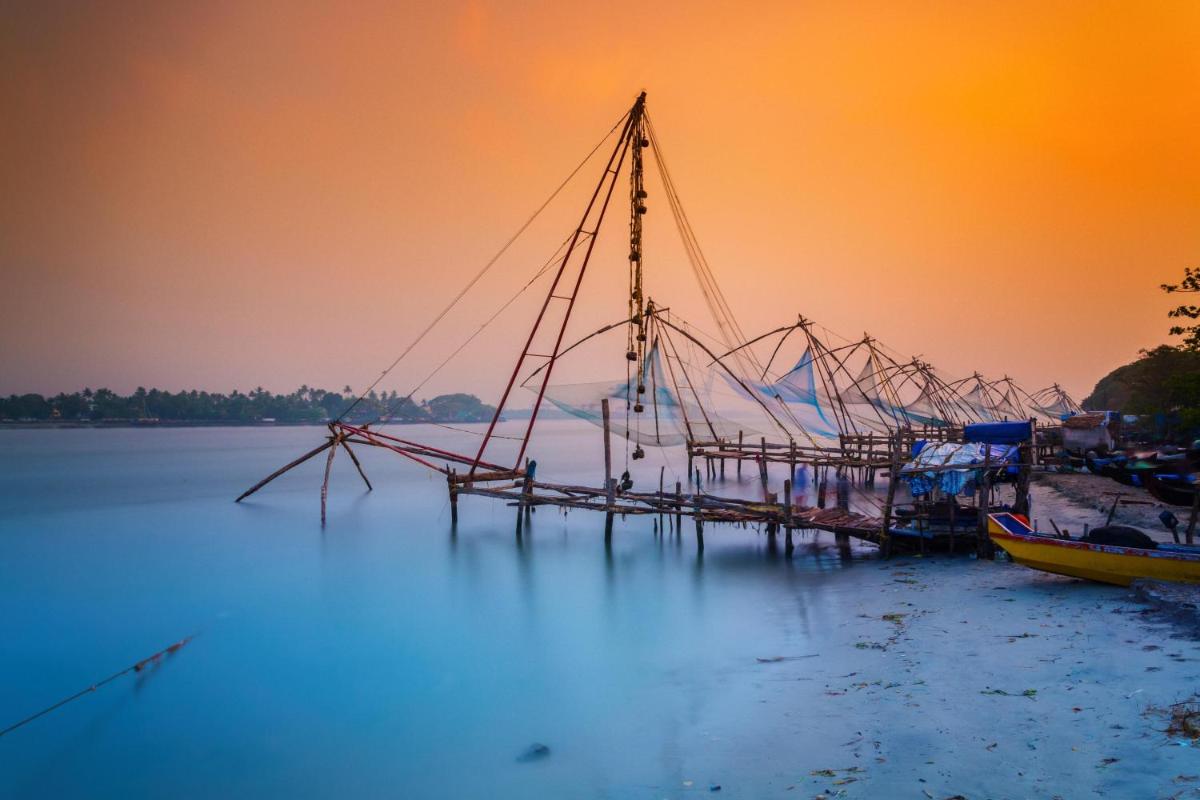 a shrimp boat is docked in the water at sunset at Radisson Blu Kochi in Cochin
