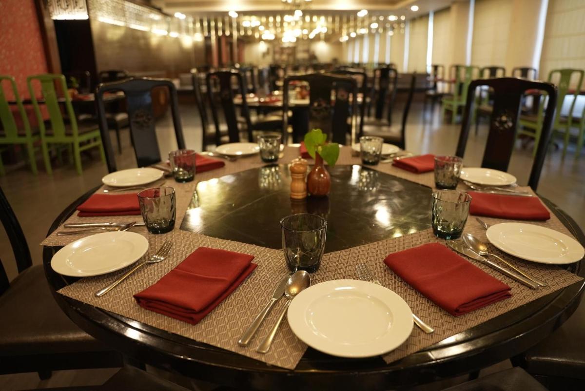 a table with white plates and red napkins on it at Radisson Blu Kochi in Cochin