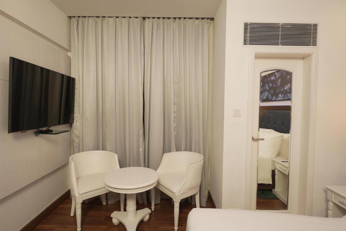 a room with two chairs and a table and a tv at Radisson Blu Kochi in Cochin