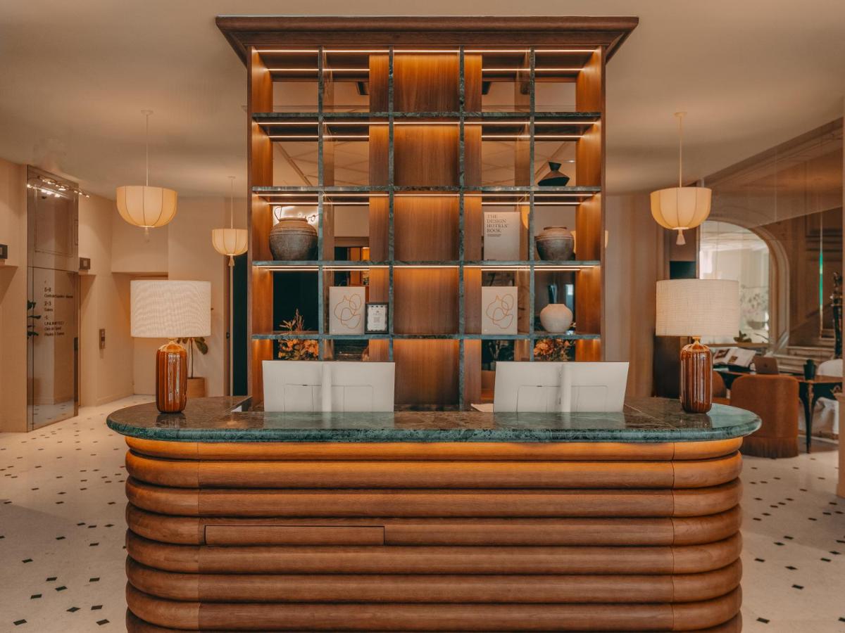 un bar dans le hall d'un hôtel avec un comptoir dans l'établissement La Maison Champs Elysées, à Paris