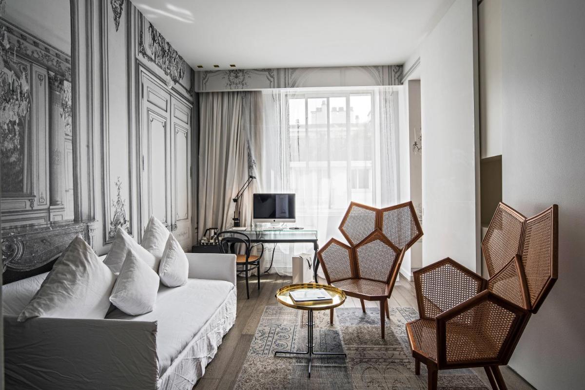 un salon avec un canapé et des chaises blanches dans l'établissement La Maison Champs Elysées, à Paris