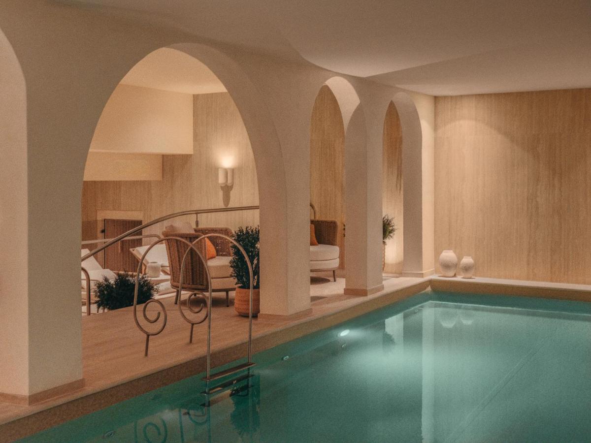 une piscine dans une pièce avec un salon dans l'établissement La Maison Champs Elysées, à Paris