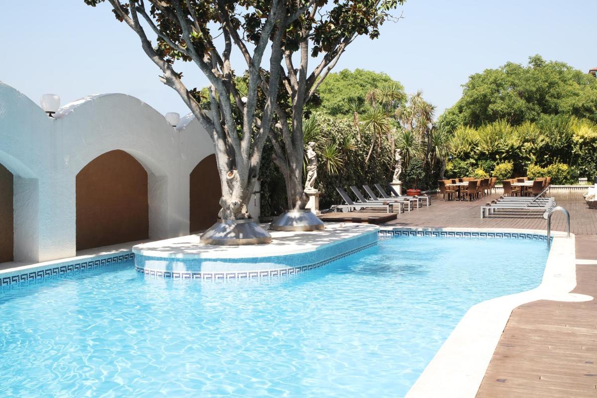 una piscina con un árbol en el medio. en Augusta Club & Spa - Adults Only, en Lloret de Mar