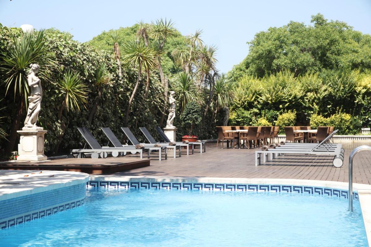 una piscina con tumbonas y una mesa y una piscina en Augusta Club & Spa - Adults Only, en Lloret de Mar