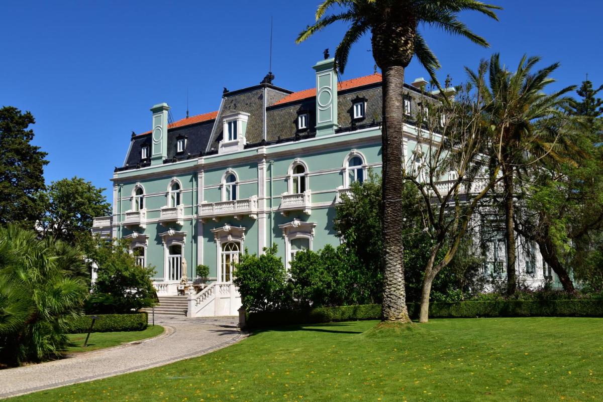 uma casa grande com uma palmeira em frente em Pestana Palace Lisboa Hotel & National Monument - The Leading Hotels of the World em Lisboa